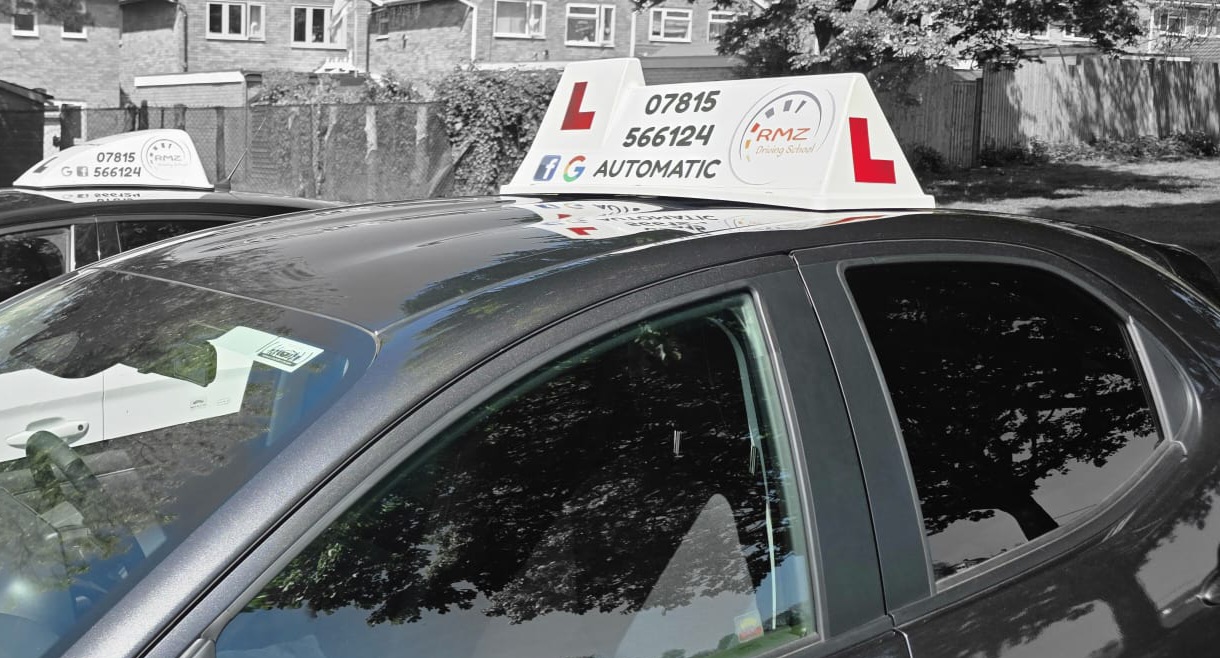 Two RMZ learner cars with rooftop signs
